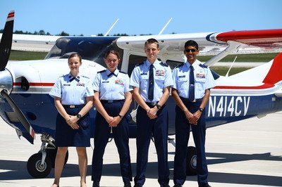 Four Civil Air Patrol members standing in front of an airplane
